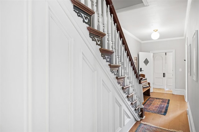 foyer with stairs, crown molding, baseboards, and wood finished floors