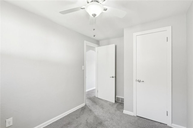 unfurnished bedroom with a ceiling fan, carpet, visible vents, and baseboards