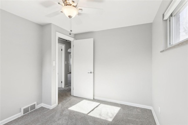 unfurnished bedroom featuring carpet, visible vents, ceiling fan, and baseboards