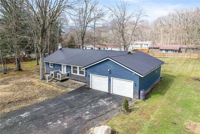 ranch-style home featuring aphalt driveway, stone siding, fence, and a front lawn