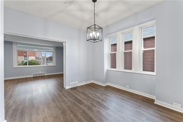 unfurnished dining area with visible vents, baseboards, and dark wood-style floors