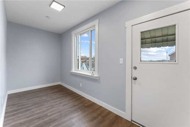 foyer featuring baseboards and dark wood-style flooring