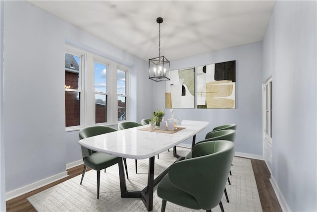 dining room with wood finished floors, baseboards, and a chandelier