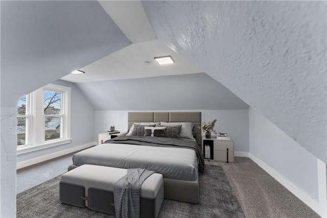 carpeted bedroom with vaulted ceiling, baseboards, and a textured ceiling