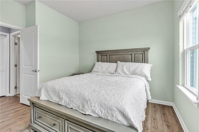 bedroom featuring light wood-style floors and baseboards