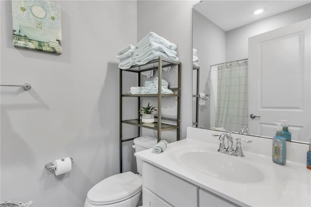 bathroom with curtained shower, vanity, and toilet