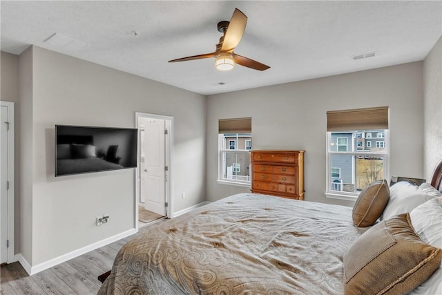 bedroom featuring visible vents, baseboards, and wood finished floors