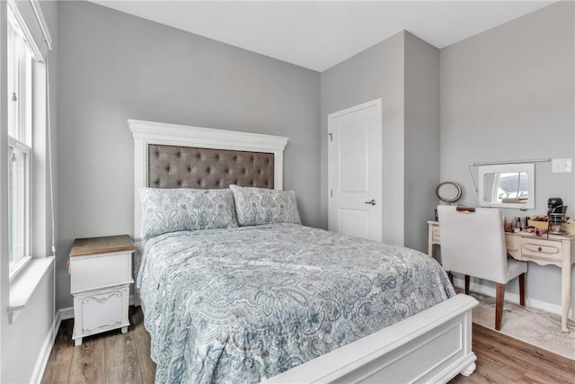 bedroom with baseboards and wood finished floors