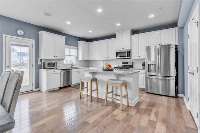 kitchen featuring a kitchen island, white cabinetry, and stainless steel appliances