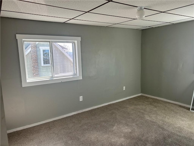 unfurnished room featuring carpet floors, a drop ceiling, and baseboards