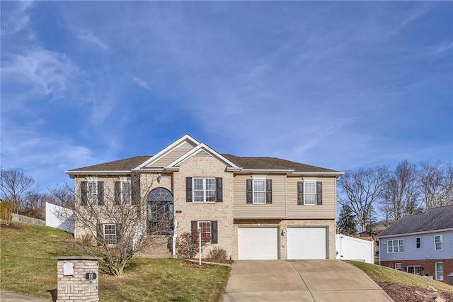 bi-level home featuring brick siding, concrete driveway, a front yard, fence, and a garage