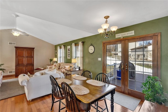 dining area featuring lofted ceiling, light wood-style floors, visible vents, and french doors