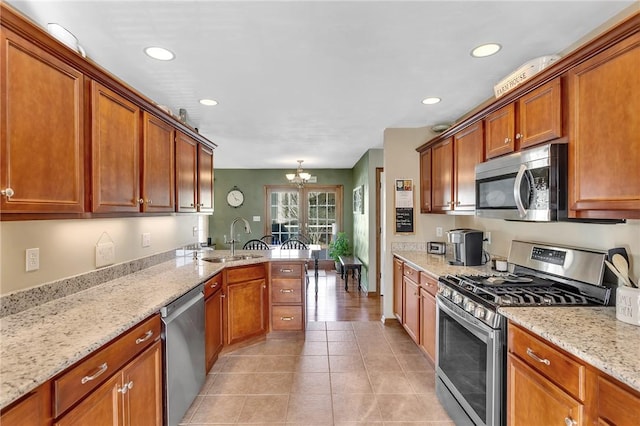 kitchen with appliances with stainless steel finishes, brown cabinets, and a sink