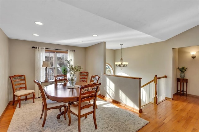 dining area with recessed lighting, lofted ceiling, an inviting chandelier, light wood-style floors, and baseboards