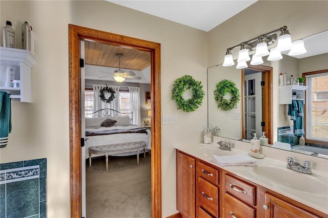 ensuite bathroom featuring ensuite bathroom, double vanity, a sink, and a ceiling fan