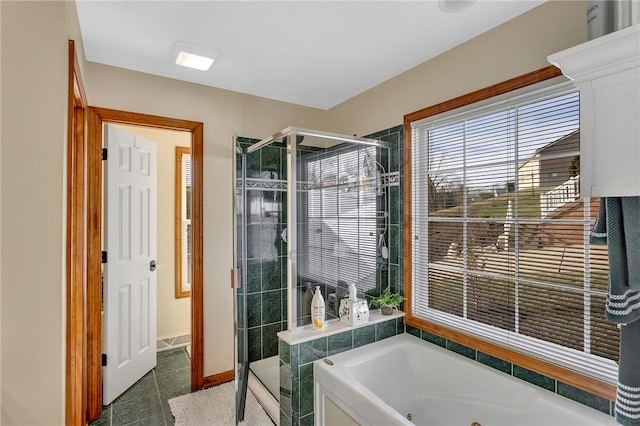 bathroom with a tub with jets and a stall shower