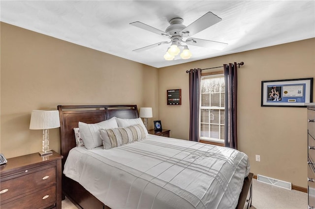 bedroom with ceiling fan, light colored carpet, visible vents, and baseboards