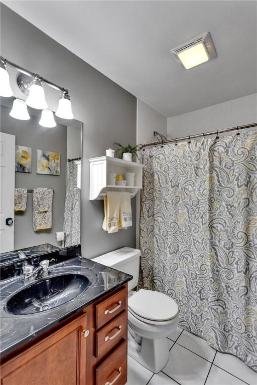 full bath with visible vents, a shower with shower curtain, toilet, vanity, and tile patterned flooring