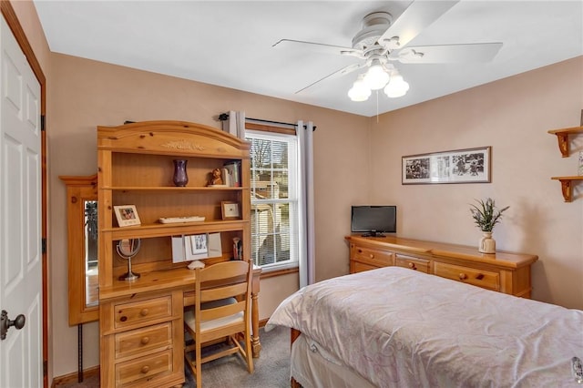 bedroom featuring a ceiling fan, carpet flooring, and built in desk