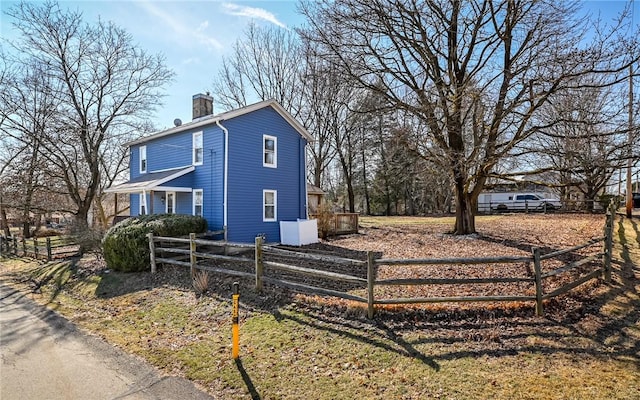 view of side of home featuring a chimney and fence