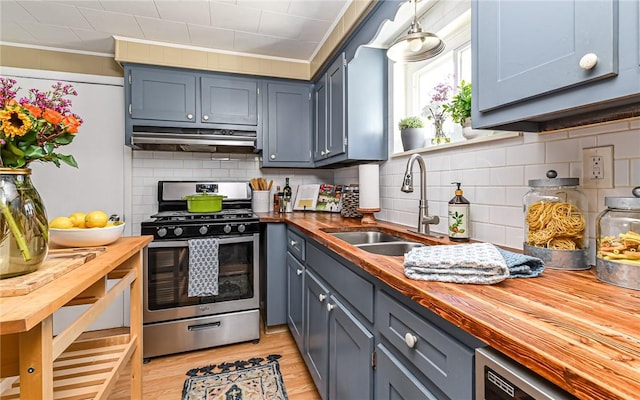 kitchen with wooden counters, stainless steel gas range oven, a sink, and range hood