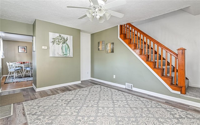 interior space with stairway, wood finished floors, and visible vents