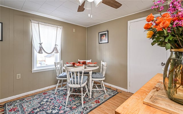 dining room featuring ornamental molding, ceiling fan, baseboards, and wood finished floors