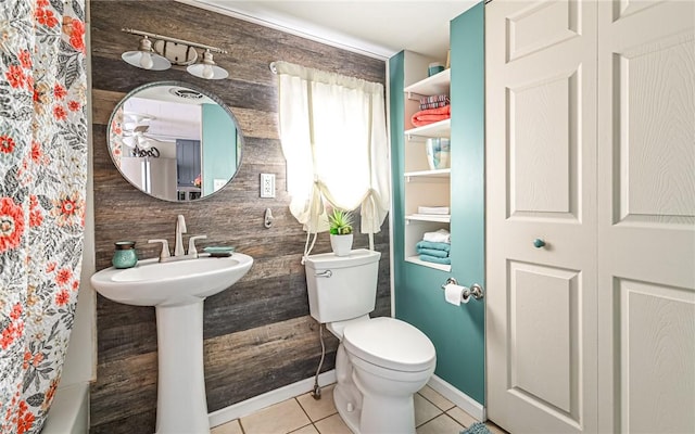 full bath with a shower with shower curtain, tile patterned flooring, toilet, and baseboards