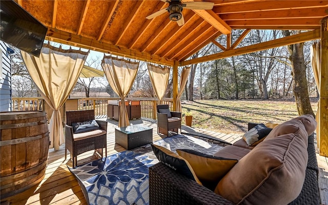 wooden terrace with a ceiling fan and outdoor lounge area