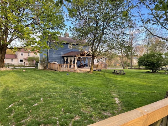 view of yard with fence, a deck, and a gazebo