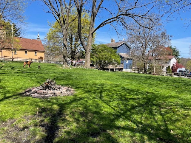 view of yard featuring an outdoor fire pit and fence