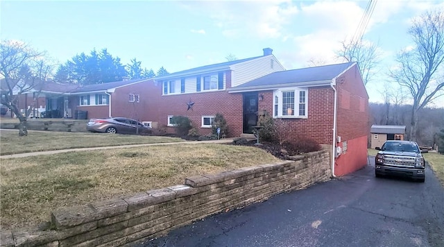 view of front facade featuring brick siding and a front yard