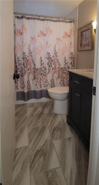 full bathroom featuring curtained shower, vanity, and toilet