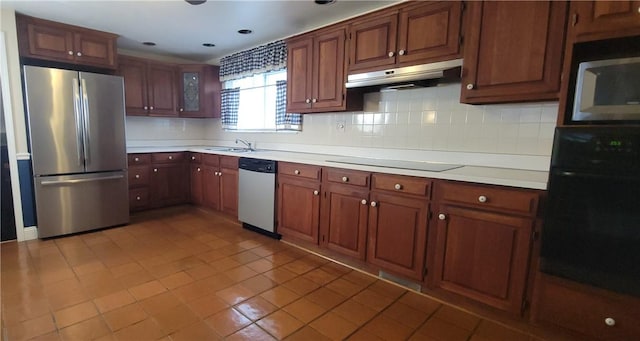 kitchen with decorative backsplash, light countertops, under cabinet range hood, and black appliances