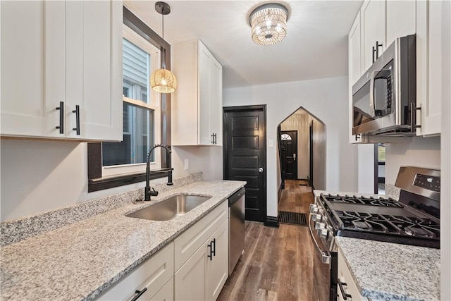 kitchen with appliances with stainless steel finishes, white cabinetry, and a sink