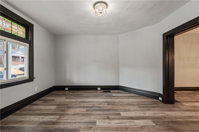 unfurnished room with baseboards and wood finished floors