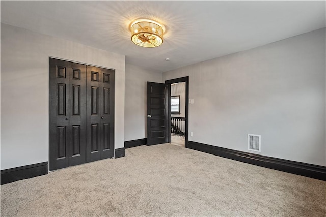 interior space featuring carpet floors, a closet, visible vents, and baseboards