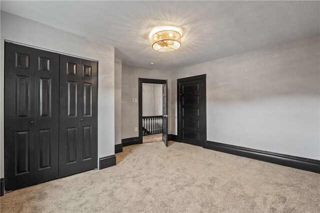 unfurnished bedroom featuring a closet, carpet, and baseboards