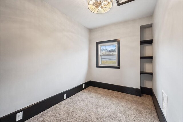 unfurnished room featuring carpet flooring, visible vents, and baseboards