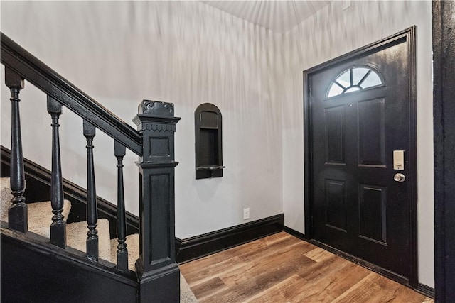 foyer with stairway, baseboards, and wood finished floors