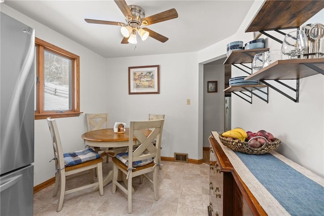 dining room with baseboards, visible vents, and ceiling fan