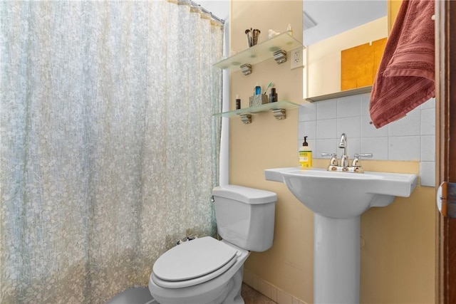 full bathroom featuring a shower with curtain, tile walls, backsplash, and toilet