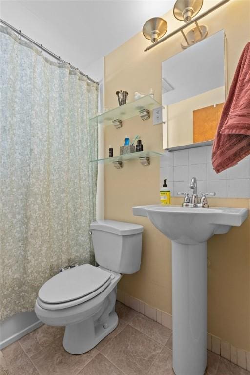 bathroom with tile patterned flooring, a shower with curtain, toilet, and decorative backsplash