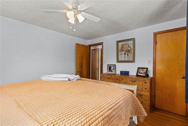 bedroom featuring a textured ceiling, a ceiling fan, and wood finished floors