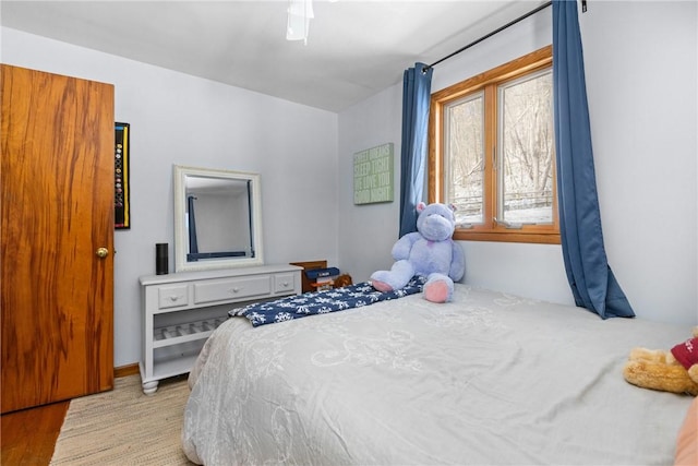 bedroom with a ceiling fan and light wood-type flooring