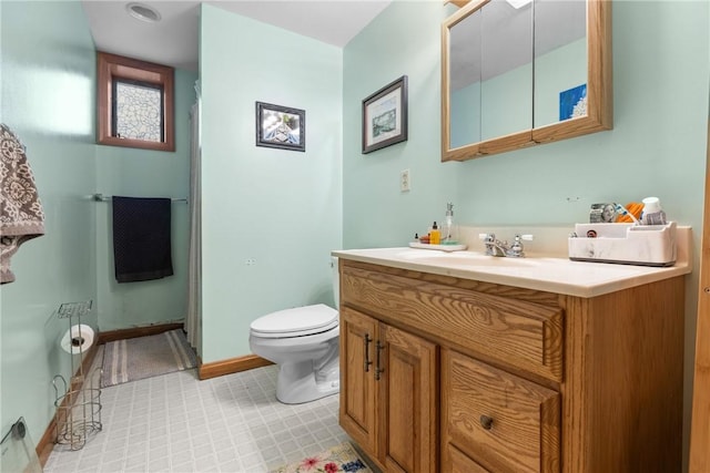 full bath with baseboards, vanity, and toilet