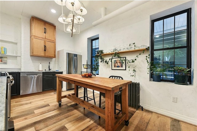 dining area featuring a chandelier, baseboards, and light wood-style floors