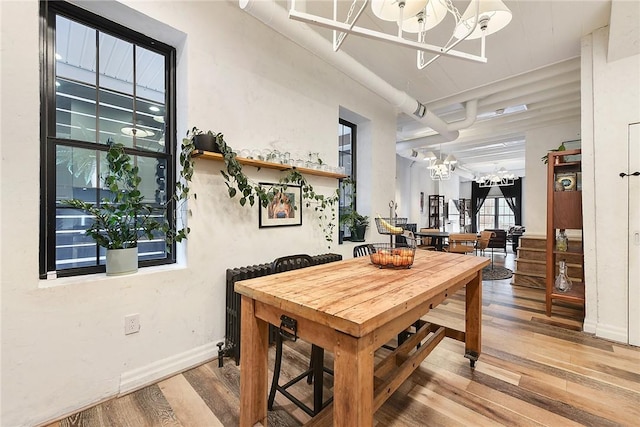 dining space with a chandelier, light wood-type flooring, and baseboards