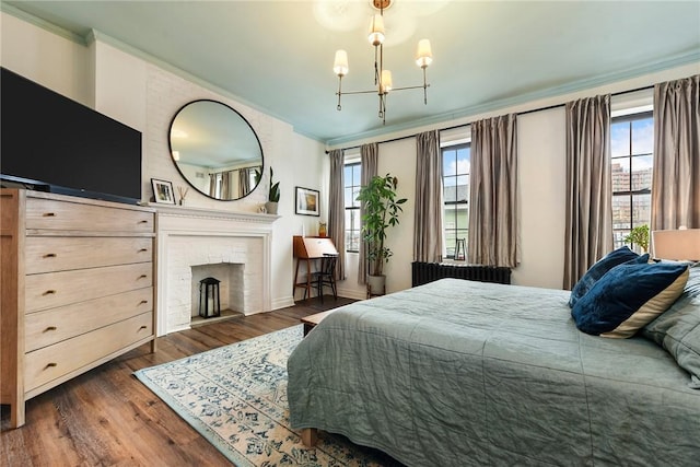 bedroom featuring ornamental molding, multiple windows, a brick fireplace, and dark wood finished floors