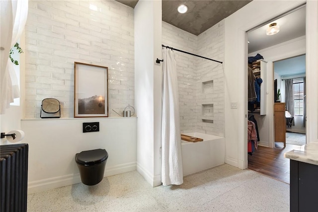 bathroom featuring shower / tub combo, radiator heating unit, baseboards, and speckled floor